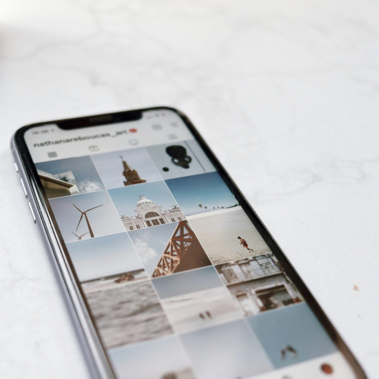 Smartphone displaying a curated Instagram grid of travel photos, illustrating social media branding strategy for RevampX clients.